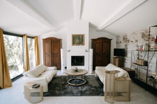 Elle comprend un salon doté d'un mobilier blanc et d'une cheminée. dans l'établissement The Aviary - Pernes-les-Fontaines, à Pernes-les-Fontaines