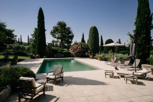 - une piscine avec des chaises et un parasol dans la cour dans l'établissement The Aviary - Pernes-les-Fontaines, à Pernes-les-Fontaines