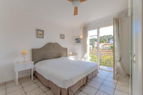 une chambre blanche avec un lit et une fenêtre dans l'établissement Floralies A l Views & Parking l Shellter Rentals, à Saint-Tropez