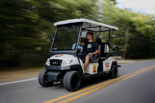 a man riding a golf cart down the road at Bayshore Resort At Put-In-Bay in Put-in-Bay