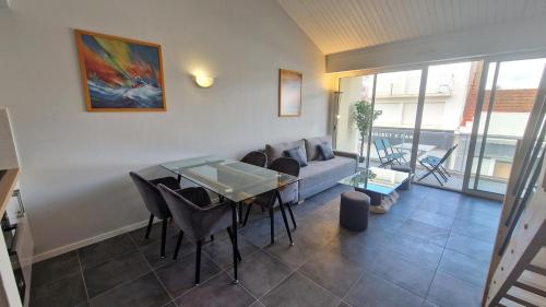 a living room with a couch and a table at Appartement T2 avec Balcon, Parking Privée à 2min de la plage, Rue Piétonne in Saint-Jean-de-Monts