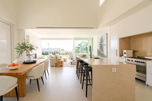 a kitchen and dining room with a table and chairs at Modern Sea View Villa, Heated Pool,Rooftop Jacuzzi Outdoor Kitchen 12min faro Airport in Santa Bárbara de Nexe