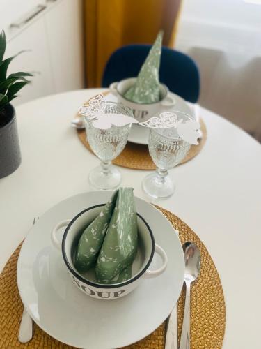 a table with two plates and a bowl of pickles at Labela Luhačovice Apartment in Luhačovice