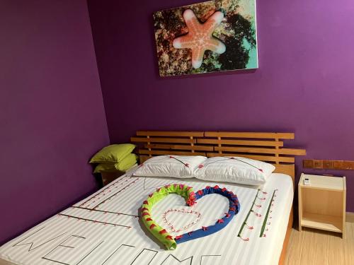 a bed with a heart shaped cake on it at Leaf fish guesthouse Maldives in Keyodhoo