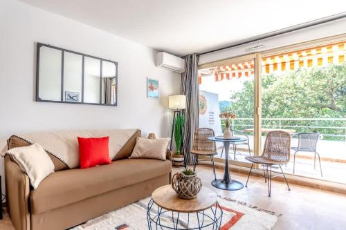 un salon avec un canapé et une table dans l'établissement L'Amoureux l Terrace & Parking l Shellter Rentals, à Saint-Tropez