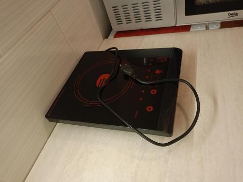 a black box with a wire plugged into a microwave at Ubytování v RV in Teplice nad Metují