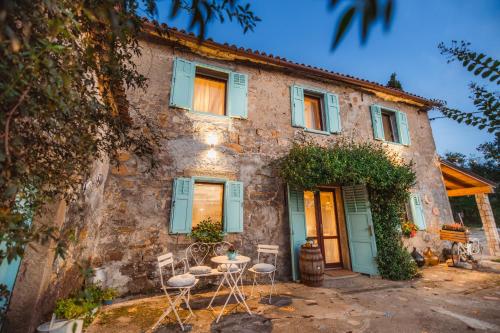 a house with chairs and a table in front of it at Vila Carla Istrska hiša in Koper