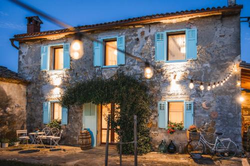 a stone house with blue windows and lights at Vila Carla Istrska hiša in Koper