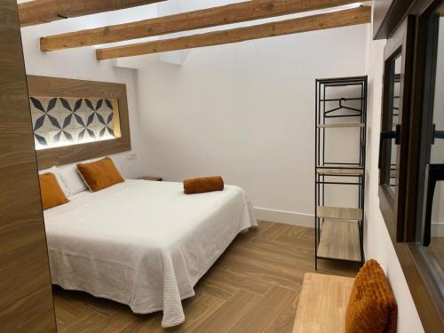 a bedroom with a white bed and a mirror at VELALMA-CERON Edificio exclusivo de apartamentos turisticos en Centro histórico in Jaén