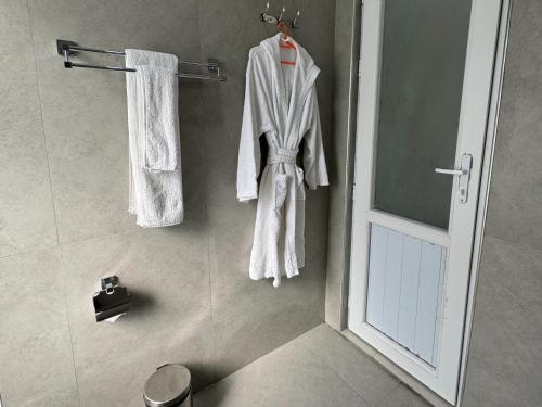 a bathroom with white towels hanging on a wall at Hidden Hills Hotel & Resort in Mānsehra