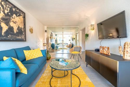 un salon avec un canapé bleu et une télévision dans l'établissement Les Amourie l Terrace & Parking l Shellter, à Saint-Tropez