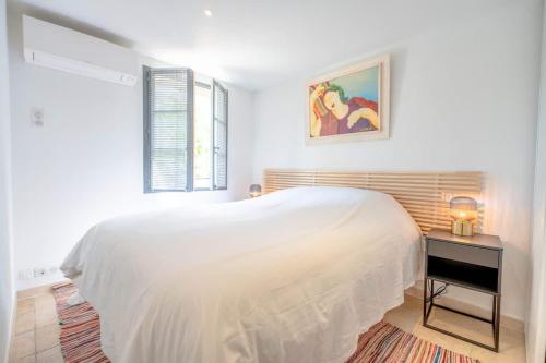 une chambre blanche avec un lit blanc et une fenêtre dans l'établissement Les Lices B l Equiped & Central l Shellter Rentals, à Saint-Tropez