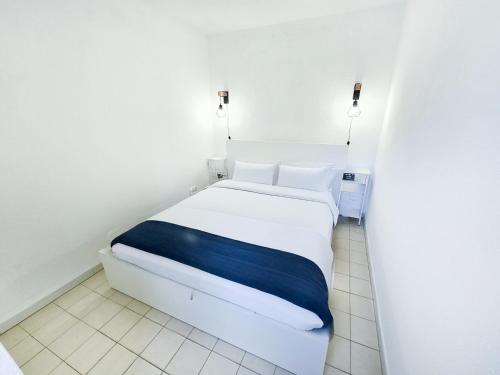 - une chambre avec un lit blanc et une couverture bleue dans l'établissement Les Plages de Cavalière T2 Cabine, au Lavandou