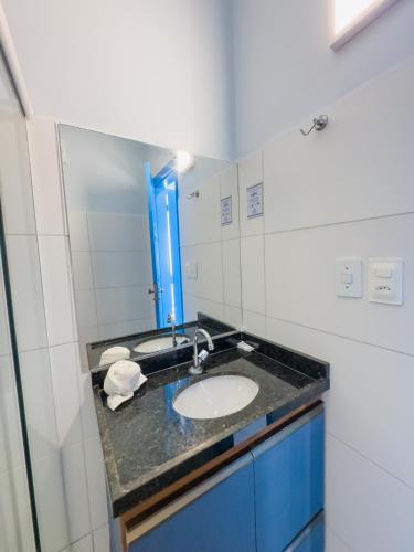 a bathroom with a sink and a mirror at Hotel Paraiso Maragogi LTDA in Maragogi