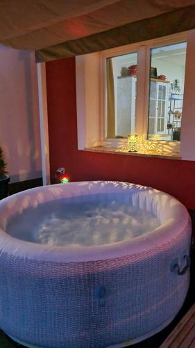 a large bath tub in a room with windows at Cosy home D&D in Brod Moravice