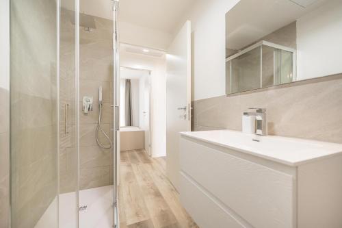 ein weißes Badezimmer mit Waschbecken und Dusche in der Unterkunft Wave Island A18 in Lido di Jesolo