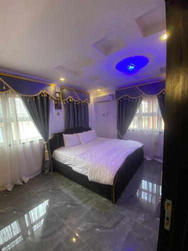 a bedroom with a large bed with a purple ceiling at Luxury 2 Bedroom Apartment in Magodo