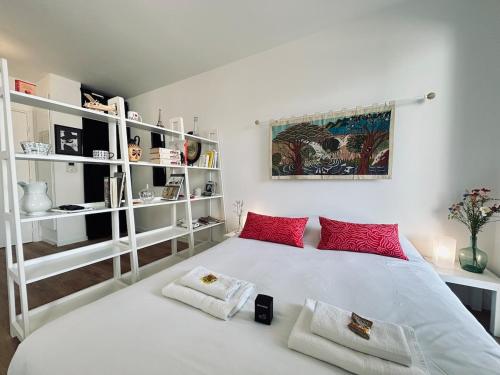 une chambre avec un grand lit blanc avec des oreillers rouges dans l'établissement Bleuets studio cosy neuf terrasse proche centre, à Reims