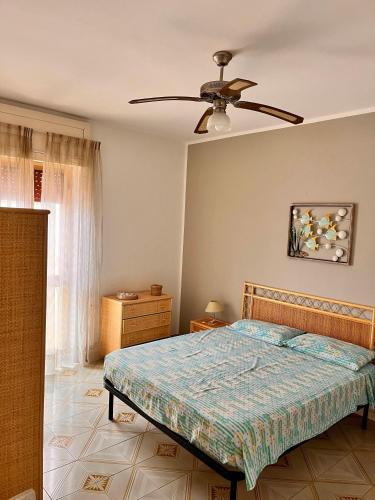 a bedroom with a bed and a ceiling fan at House on the beach in Lido Marini