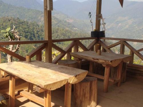 a wooden table and bench on a balcony with a view at Lodenla Homestay By StayApart in Thode