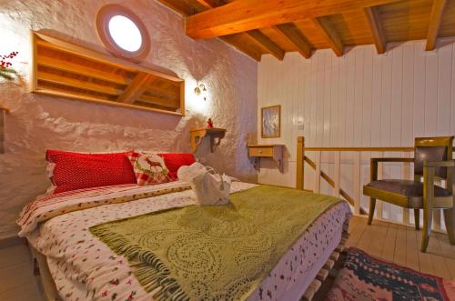 ein Schlafzimmer mit einem Bett und einem Stuhl in einem Zimmer in der Unterkunft Lilyum Alaçatı - Taş Ev in Alacati