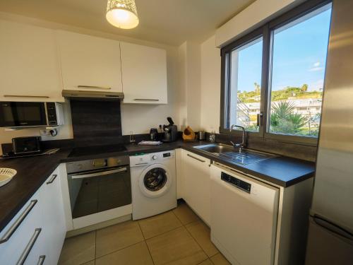 une cuisine avec un évier et une machine à laver dans l'établissement Appartement CATALINA - Double terrasse - WIFI - Clim - PORTICCIO, à Porticcio