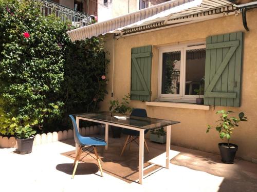 une table et une chaise bleue devant le bâtiment dans l'établissement Maison de centre ville avec jacuzzi, à Nîmes