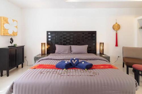 a bedroom with a large bed with blue bows on it at Cosi Flat & Pool - Chaweng Area in Chaweng