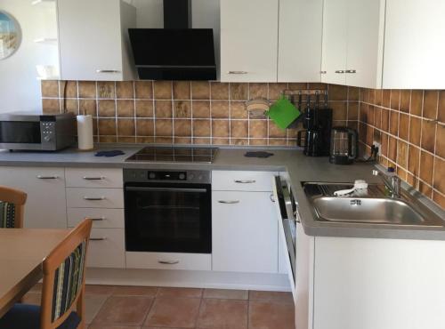 a kitchen with a sink and a stove top oven at Seerose in Wittdün