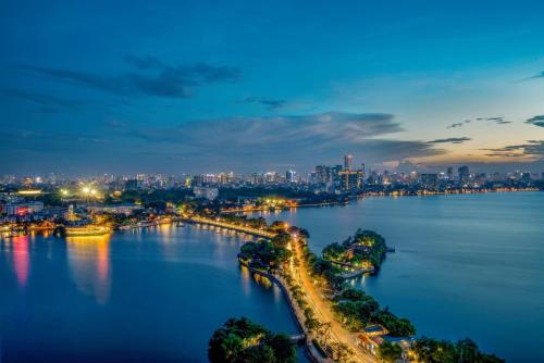 a view of a river with a city at night at Pan Pacific Hanoi in Hanoi