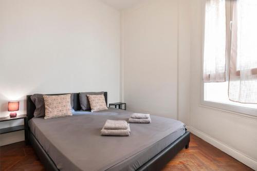- un lit dans une chambre blanche avec 2 serviettes dans l'établissement Central & Cosy, à Nice
