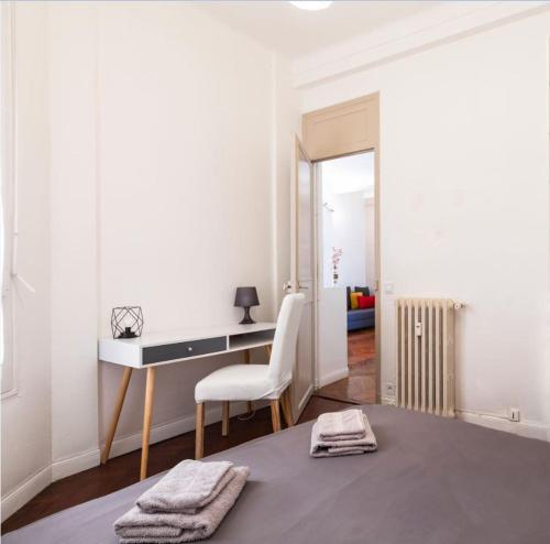 Cette chambre blanche dispose d'un bureau et d'une chaise. dans l'établissement Central & Cosy, à Nice