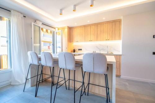 une cuisine avec une table et des tabourets blancs dans l'établissement Le Sublime l View & Terrace l Shellter Rentals, à Saint-Tropez