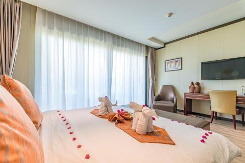 a hotel room with a bed with stuffed animals on it at BJ & Radisson Sea View Hotel in Ko Yao Yai