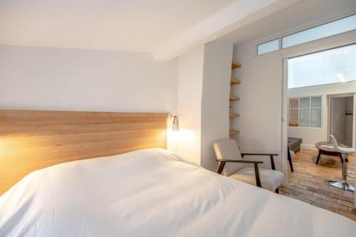 une chambre avec un lit, une chaise et une fenêtre dans l'établissement Le Gambetta l Near the Port l Shellter Rentals, à Saint-Tropez