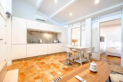 une cuisine avec des armoires blanches et une table en bois dans l'établissement Le Gambetta l Near the Port l Shellter Rentals, à Saint-Tropez