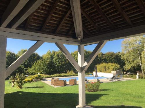 a pavilion with a view of a swimming pool at Domaine des Tilleuls - Grand Jardin avec Piscine privée sur le Canal de Bourgogne in Ravières