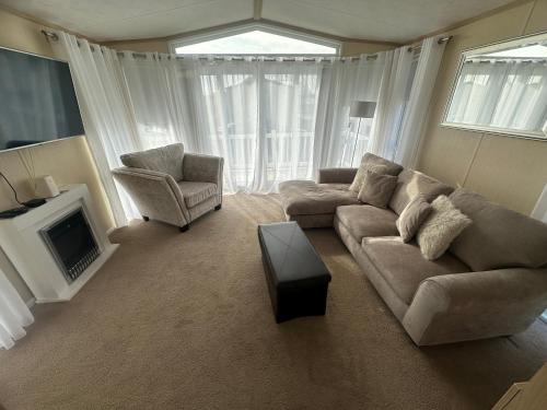 a living room with a couch and a chair at Sunnymede I14 Keyshare holiday lets 6 Berth in Ingoldmells