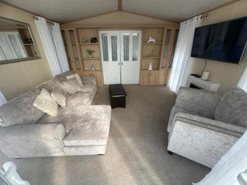 a living room with two couches and a tv at Sunnymede I14 Keyshare holiday lets 6 Berth in Ingoldmells