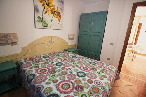 a bedroom with a bed with a colorful bedspread at Appartamento Mare Verde - Portu Maga in Portu Maga