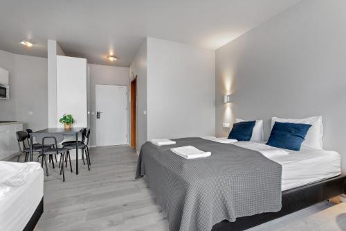 a bedroom with a bed and a table with chairs at Iceland Comfort Apartments by Heimaleiga in Reykjavík