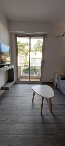 un salon avec une table et une grande fenêtre dans l'établissement Studio Cosy proche Carlone, balcon, à Nice