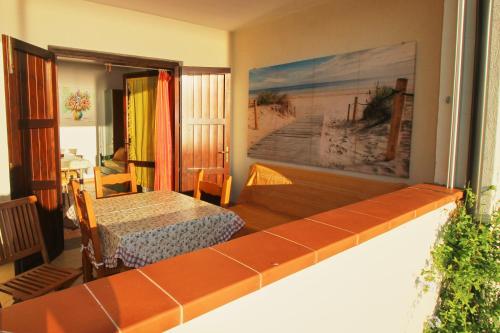 a room with a balcony with a bed and a table at Appartamento Mare Verde - Portu Maga in Portu Maga