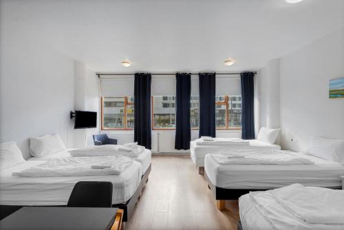 a room with four beds in it with windows at Iceland Comfort Apartments by Heimaleiga in Reykjavík