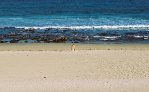 a person standing on a beach near the ocean at Secret Sunrise in Jeffreys Bay