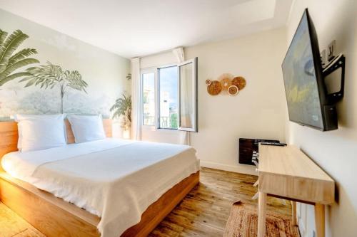 une chambre avec un lit et une télévision à écran plat dans l'établissement La Florida l Terrace & Beach l Shellter Rentals, à Saint-Tropez