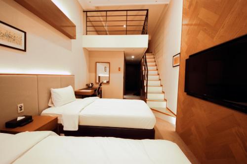 a hotel room with two beds and a flat screen tv at Pyeongchang Space hubt Hotel & Resort in Pyeongchang 