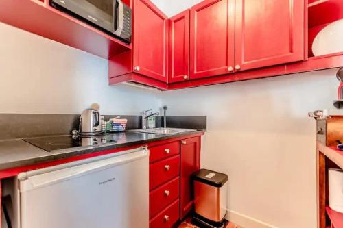 - une cuisine rouge avec des placards rouges et un évier dans l'établissement La Ponche l Beachside l Shellter Rentals, à Saint-Tropez