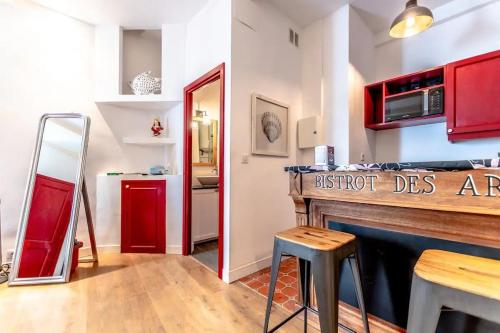 une cuisine avec des placards rouges et un comptoir avec un tabouret dans l'établissement La Ponche l Beachside l Shellter Rentals, à Saint-Tropez