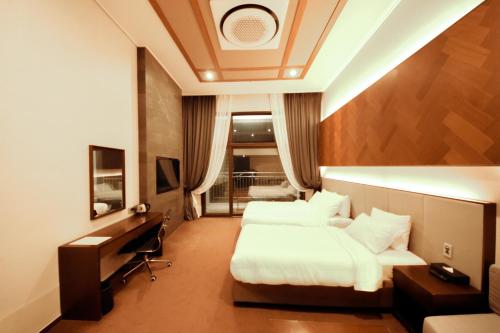 a hotel room with two beds and a desk at Pyeongchang Space hubt Hotel & Resort in Pyeongchang 
